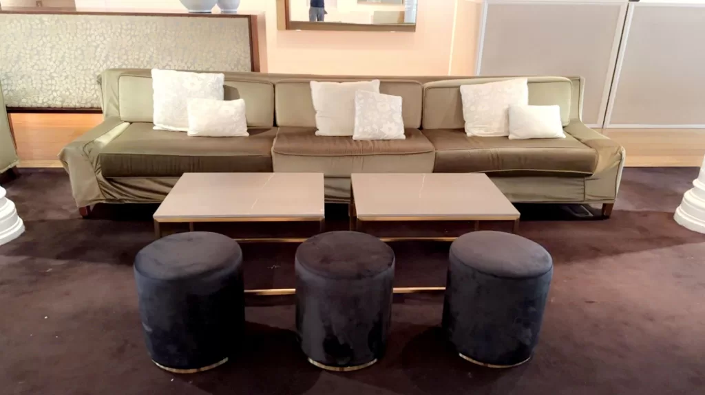 gold rectangular coffee table with black marble table top with black velvet ottoman stool at an event