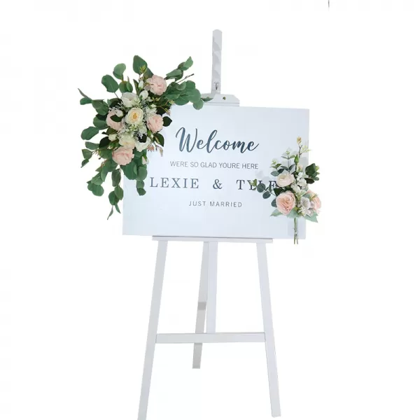 white wooden easel with a sign and florals attached