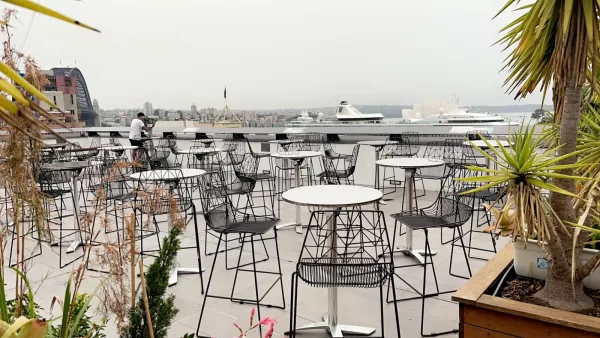 stainless steel cocktail bar table with black wire cocktail stool on a rooftop