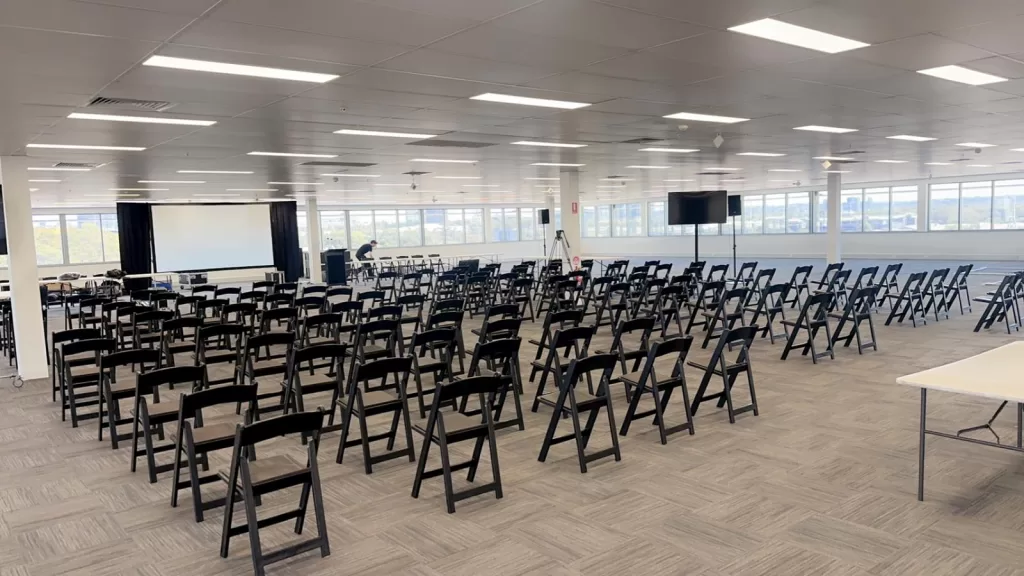 Black padded folding chairs set up at an office space