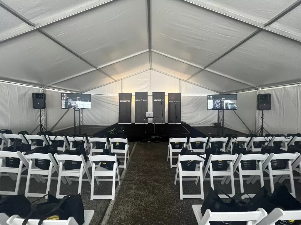 corporate tv with white padded folding chairs with speakers