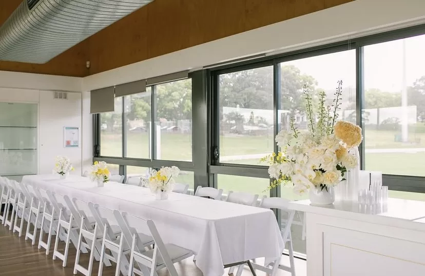 White padded chairs adorned with trestle tables
