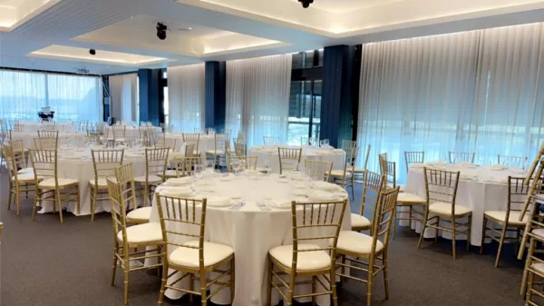 wedding reception at a venue with gold tiffany chairs and round banquet tables