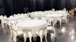 plastic white chairs around a banquet round table
