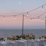outdoor wedding with festoon lights hung up on poles