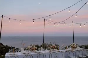 outdoor wedding with festoon lights hung up on poles